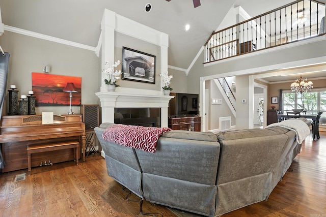 28 Chemin Ct, Little Rock, AR 72223 - living area with stairs, wood finished floors, a chandelier, a tiled fireplace, and ceiling fan