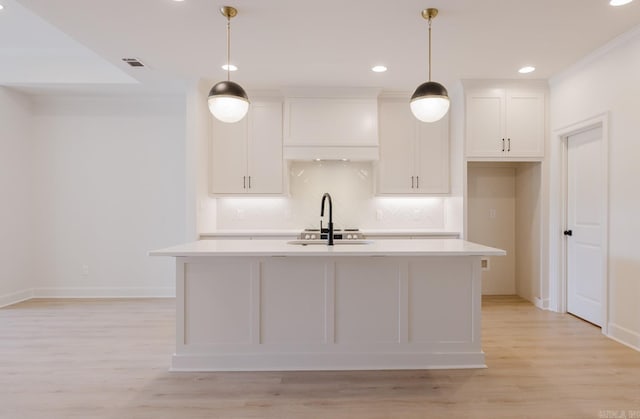 127 Edgewood Cir, Little Rock, AR 72223 - kitchen with light countertops, white cabinetry, tasteful backsplash, a center island with sink, and recessed lighting