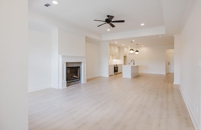 127 Edgewood Cir, Little Rock, AR 72223 - unfurnished living room with a ceiling fan, light wood-style floors, a tiled fireplace, crown molding, and recessed lighting