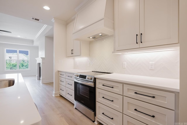 127 Edgewood Cir, Little Rock, AR 72223 - kitchen featuring electric stove, custom range hood, backsplash, light countertops, and light wood-style floors