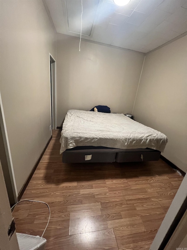 bedroom with attic access and wood finished floors
