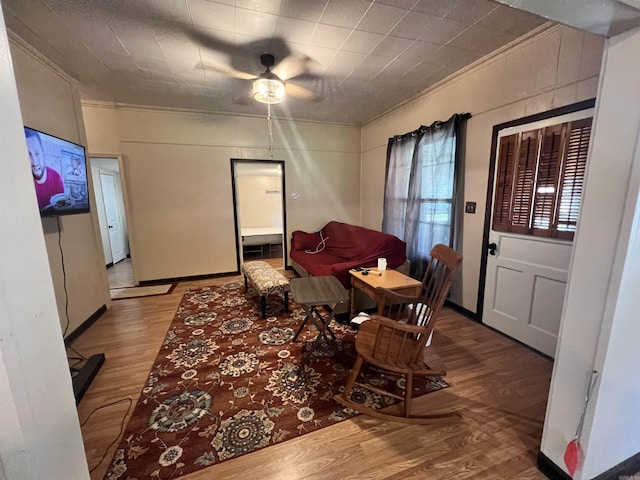 dining room with wood finished floors, crown molding, and a ceiling fan