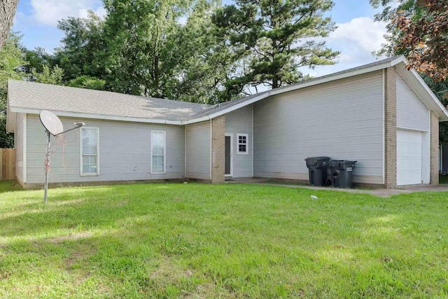 1607 W Washington Ave, Jonesboro, AR 72401 - back of house with a lawn, a garage, and brick siding