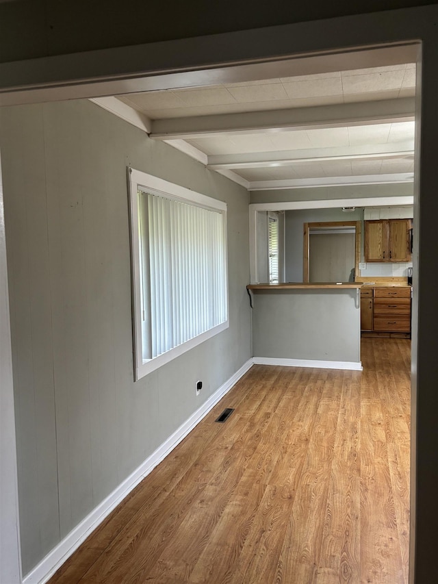 1702 S Ruddle Rd, Blytheville, AR 72315 - unfurnished living room with beam ceiling and light wood-style flooring