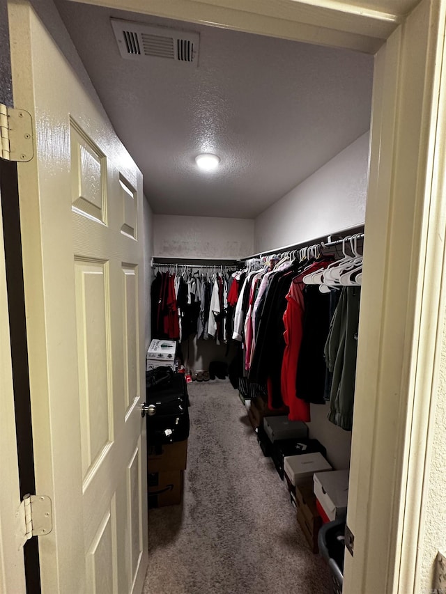 walk in closet featuring carpet flooring