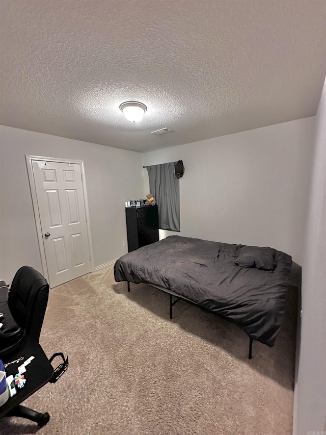 bedroom with carpet floors and a textured ceiling