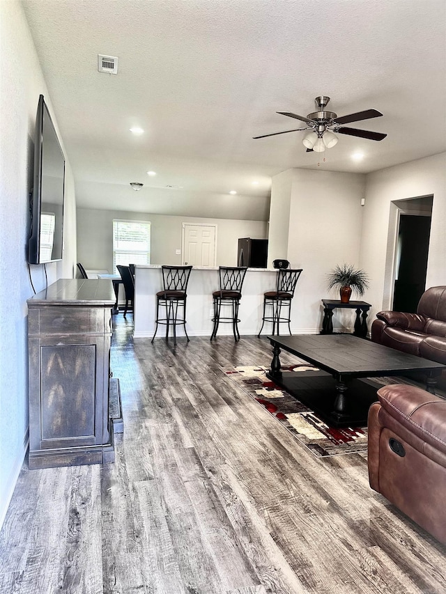 living room with wood finished floors, a ceiling fan, and recessed lighting