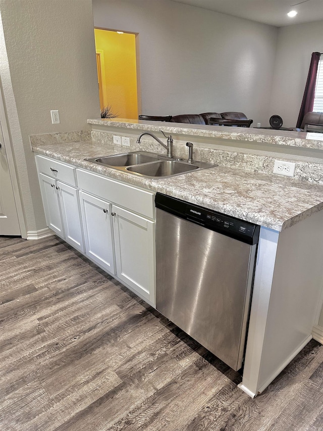 kitchen featuring stainless steel dishwasher, dark wood-style floors, and white cabinetry