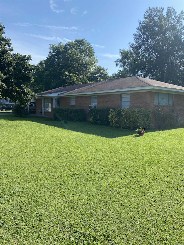 back of house with a yard and brick siding