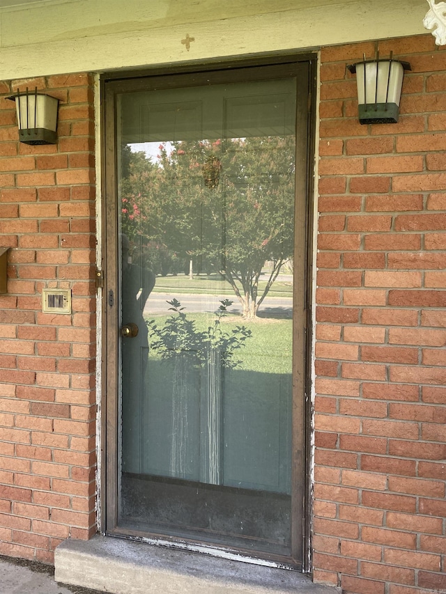 view of exterior entry with brick siding