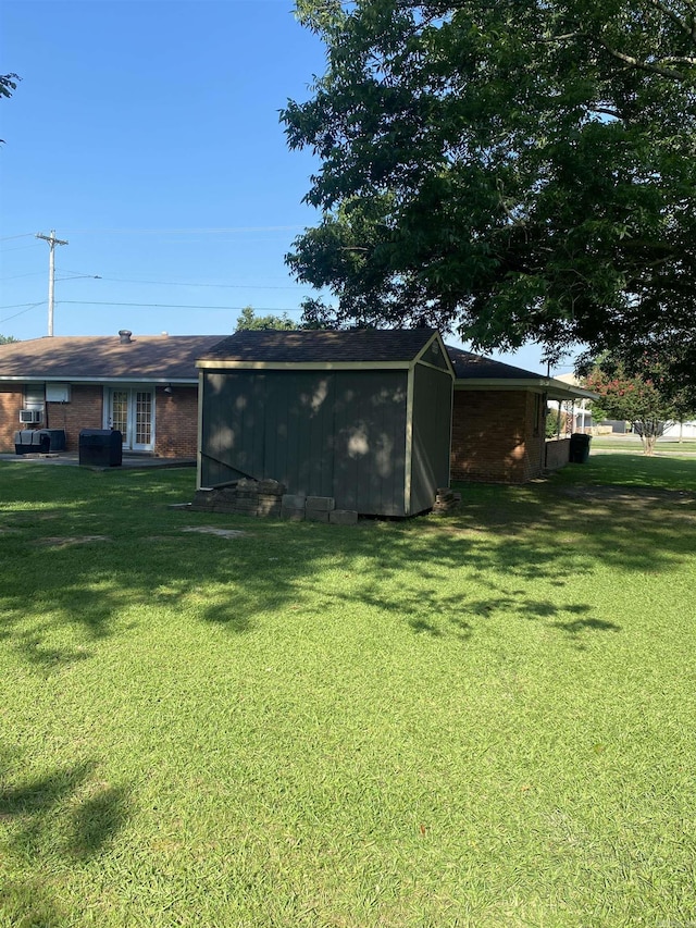 view of green lawn with a storage unit