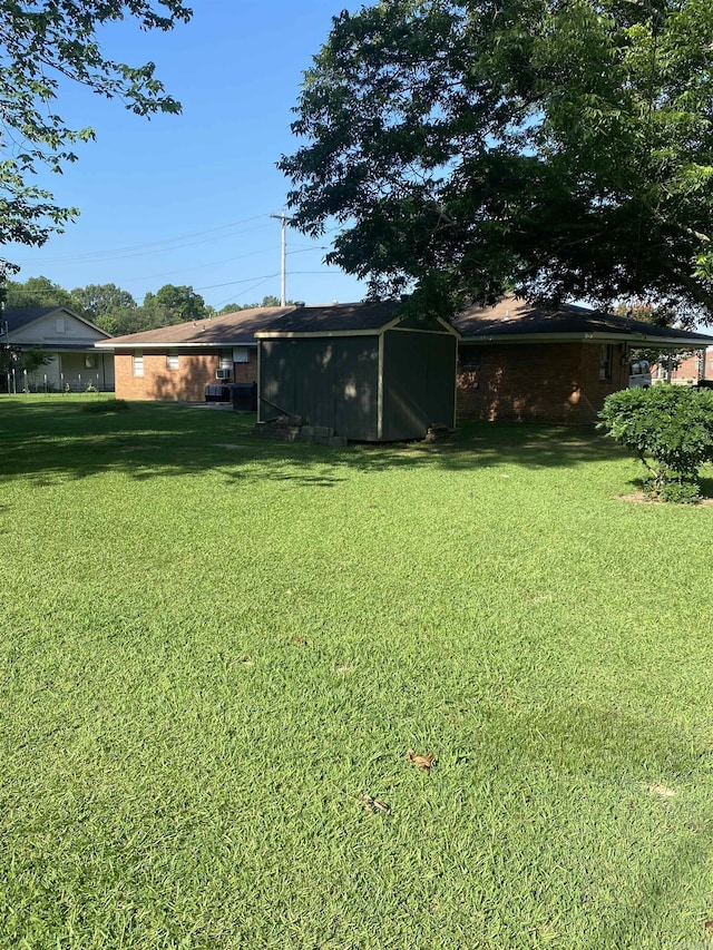 view of green lawn with a shed