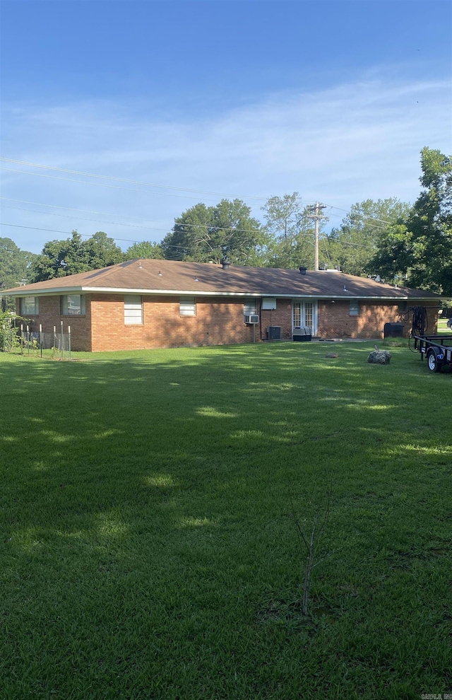 back of property with brick siding and a lawn