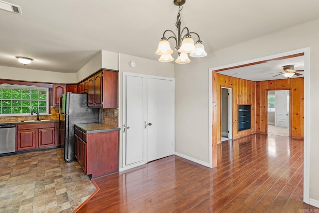 901 S Reine St, Mena, AR 71953 - kitchen featuring dishwasher, decorative backsplash, dark countertops, a chandelier, and wooden walls
