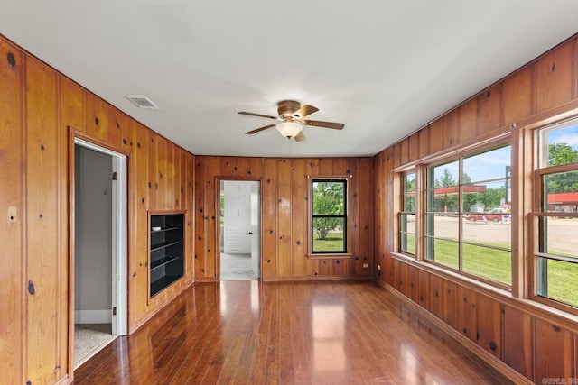 901 S Reine St, Mena, AR 71953 - unfurnished living room featuring wood walls, dark wood finished floors, and ceiling fan
