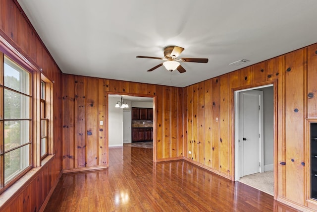 901 S Reine St, Mena, AR 71953 - spare room with wood finished floors, wood walls, ceiling fan, and a chandelier