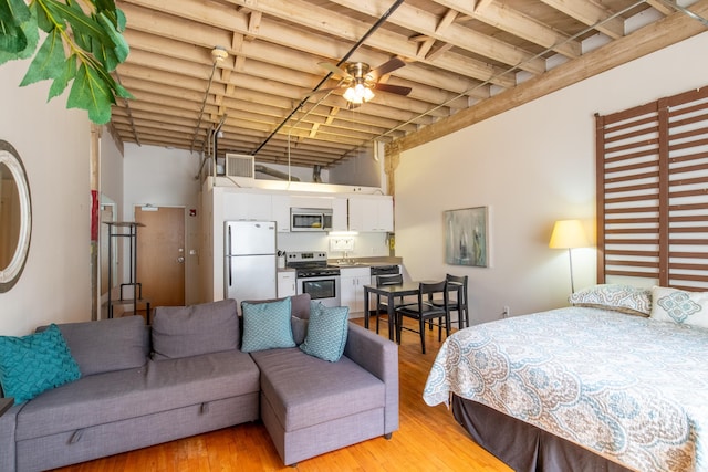 423 E 3rd St Unit 216, Little Rock, AR 72201 - bedroom featuring freestanding refrigerator, a towering ceiling, and light wood-type flooring