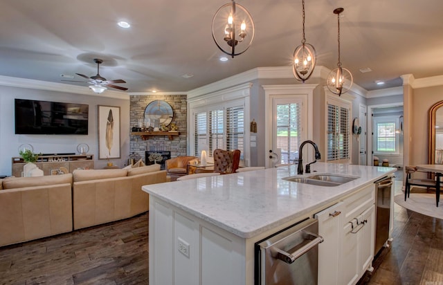 7517 Garden Way, Sherwood, AR 72120 - kitchen with ornamental molding, plenty of natural light, a center island with sink, dark wood-style floors, and a stone fireplace