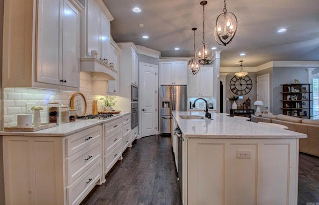 7517 Garden Way, Sherwood, AR 72120 - kitchen with stainless steel appliances, open floor plan, tasteful backsplash, a kitchen island with sink, and white cabinets