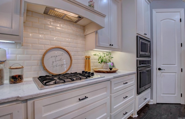 7517 Garden Way, Sherwood, AR 72120 - kitchen featuring stainless steel appliances, custom range hood, decorative backsplash, white cabinets, and light stone counters
