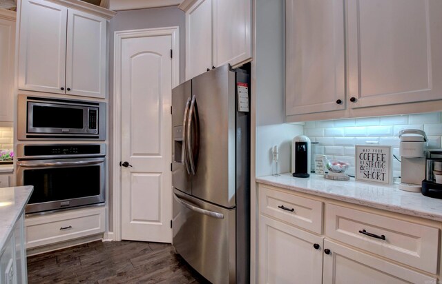 7517 Garden Way, Sherwood, AR 72120 - kitchen featuring stainless steel appliances, decorative backsplash, dark wood-style floors, light stone countertops, and white cabinetry