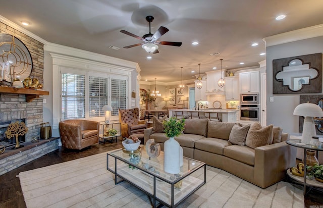 7517 Garden Way, Sherwood, AR 72120 - living area featuring crown molding, a ceiling fan, a stone fireplace, light wood-style flooring, and a chandelier
