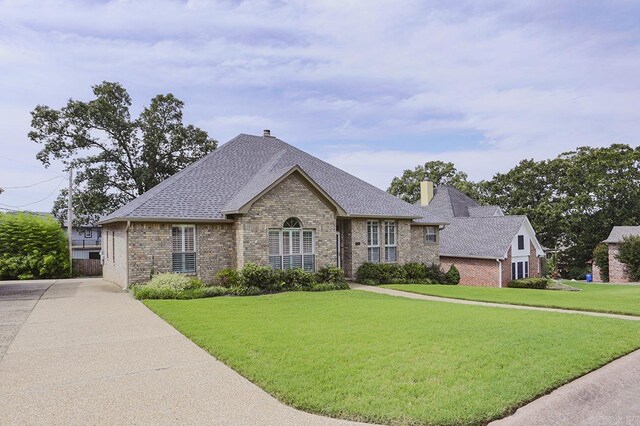 1224 N Pt, North Little Rock, AR 72118 - french country style house featuring brick siding, a chimney, a front yard, and roof with shingles