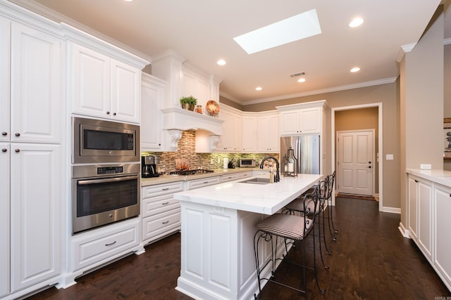 8 Flint Creek Ct, Little Rock, AR 72223 - kitchen with appliances with stainless steel finishes, a skylight, backsplash, white cabinetry, and crown molding