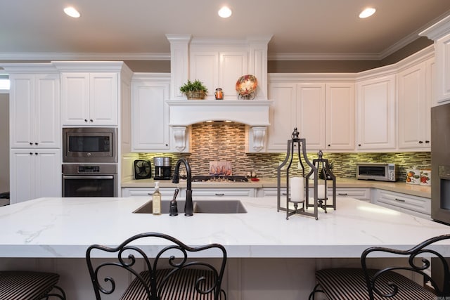 8 Flint Creek Ct, Little Rock, AR 72223 - kitchen with appliances with stainless steel finishes, a kitchen breakfast bar, white cabinetry, backsplash, and recessed lighting