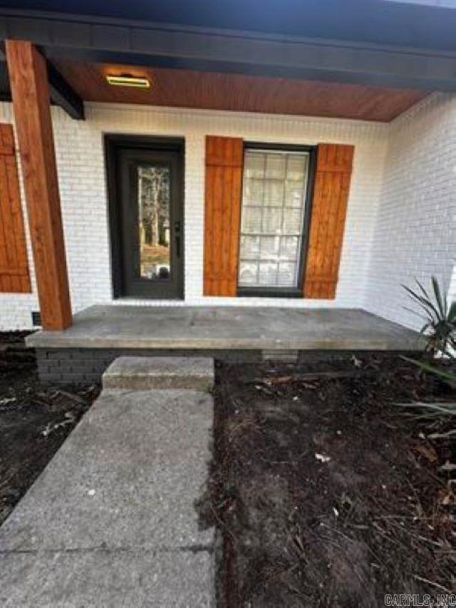 9701 Woodland Dr, Mabelvale, AR 72103 - doorway to property with a porch and brick siding