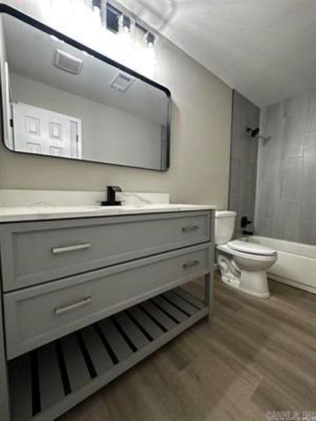 9701 Woodland Dr, Mabelvale, AR 72103 - full bath featuring wood finished floors, vanity, and bathtub / shower combination