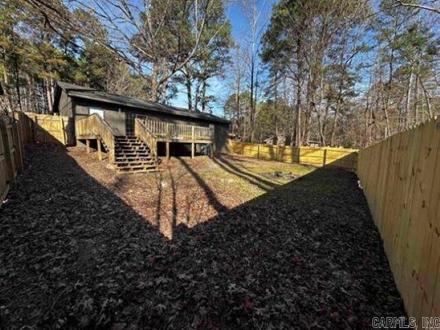 9701 Woodland Dr, Mabelvale, AR 72103 - fenced backyard featuring stairs and a wooden deck