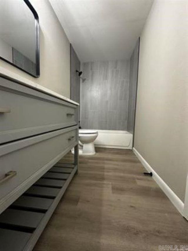 9701 Woodland Dr, Mabelvale, AR 72103 - bathroom with a tile shower, wood finished floors, and vanity