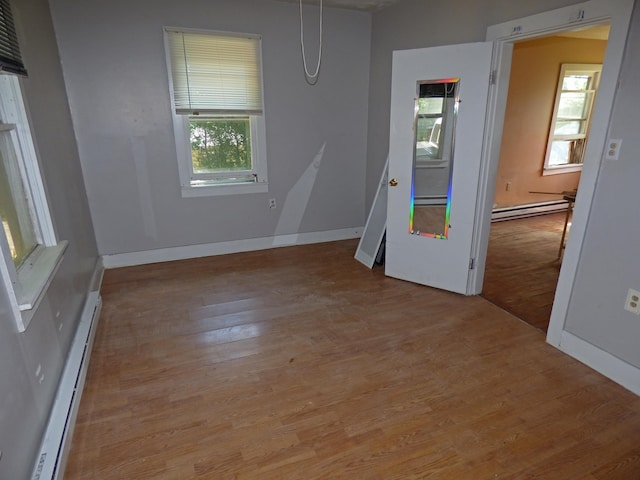 102 E Second St, Hardy, AR 72542 - empty room featuring baseboard heating, a baseboard radiator, wood finished floors, and plenty of natural light