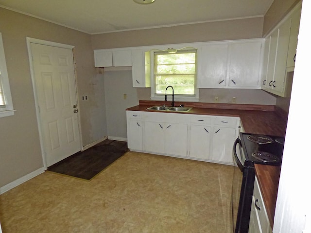 110 E First St, Hardy, AR 72542 - kitchen with electric range, white cabinets, light flooring, and crown molding