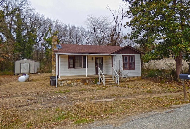 104 W First St, Hardy, AR 72542 - view of front of house featuring covered porch, a storage unit, a chimney, and crawl space
