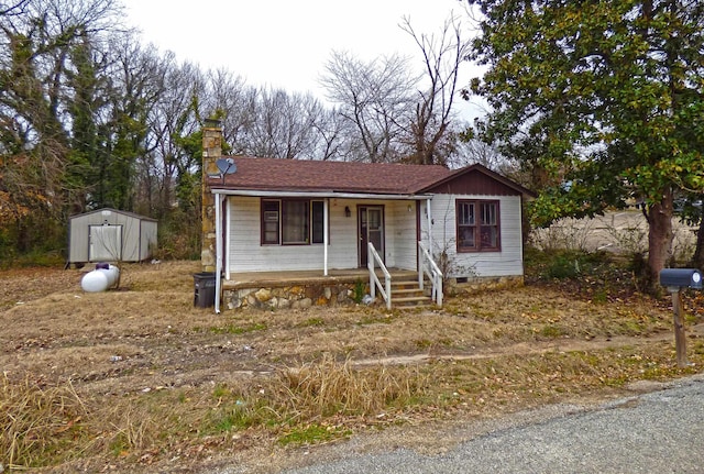 104 W First St, Hardy, AR 72542 - view of front of home featuring a porch, a shed, a chimney, and crawl space