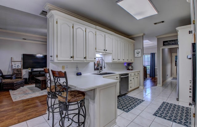 4600 Lexington Park Cir, Bryant, AR 72022 - kitchen with dishwasher, a kitchen bar, light tile patterned flooring, crown molding, and a peninsula