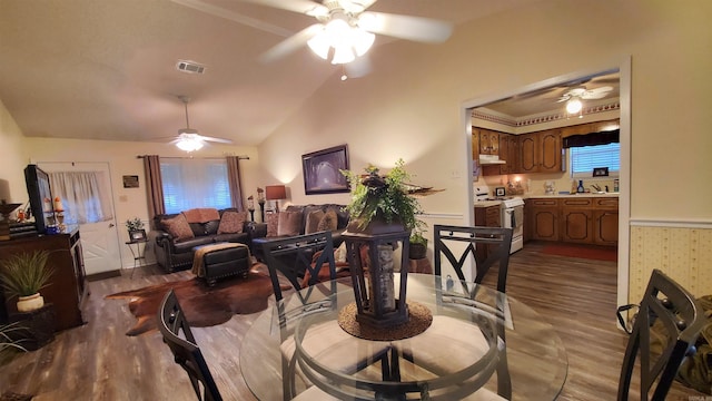 81 Pheasant Run Dr, Cabot, AR 72023 - dining area featuring ceiling fan, wood finished floors, vaulted ceiling, and a wainscoted wall