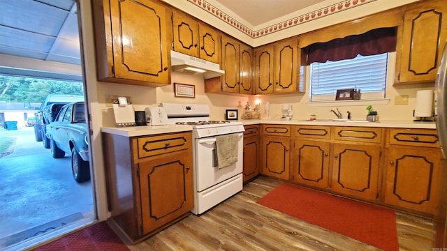 81 Pheasant Run Dr, Cabot, AR 72023 - kitchen featuring white gas range, under cabinet range hood, wood finished floors, and brown cabinetry