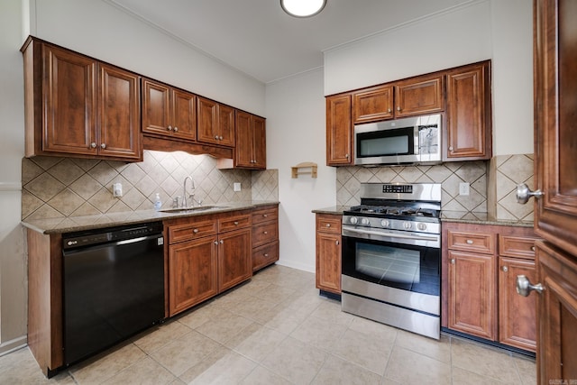205 S Martin St, Little Rock, AR 72205 - kitchen with appliances with stainless steel finishes, dark stone countertops, backsplash, light tile patterned floors, and crown molding