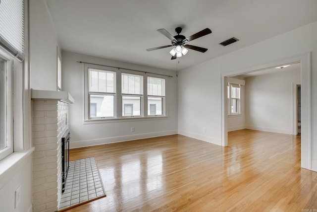 205 S Martin St, Little Rock, AR 72205 - unfurnished living room with a ceiling fan, plenty of natural light, a brick fireplace, and light wood-type flooring