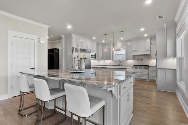 148 Irene Cir, Greenbrier, AR 72058 - kitchen featuring stainless steel appliances, a large island, decorative backsplash, wood finished floors, and recessed lighting