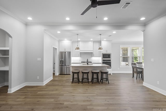 49 Saffron Cir, Little Rock, AR 72223 - kitchen featuring stainless steel appliances, an island with sink, a breakfast bar area, crown molding, and white cabinets
