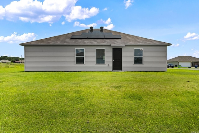 116 Baldwin Dr, Beebe, AR 72012 - rear view of house featuring roof mounted solar panels, a lawn, and roof with shingles