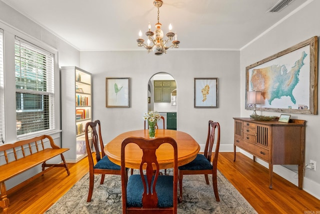 127 W F Ave, North Little Rock, AR 72116 - dining room with arched walkways, wood finished floors, a chandelier, and crown molding