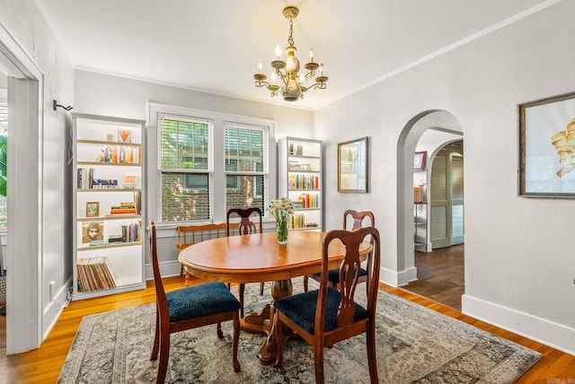127 W F Ave, North Little Rock, AR 72116 - dining room with arched walkways, a chandelier, and light wood-type flooring