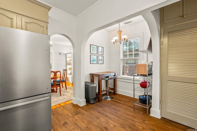 127 W F Ave, North Little Rock, AR 72116 - dining space featuring arched walkways, dark wood-style flooring, a chandelier, and crown molding