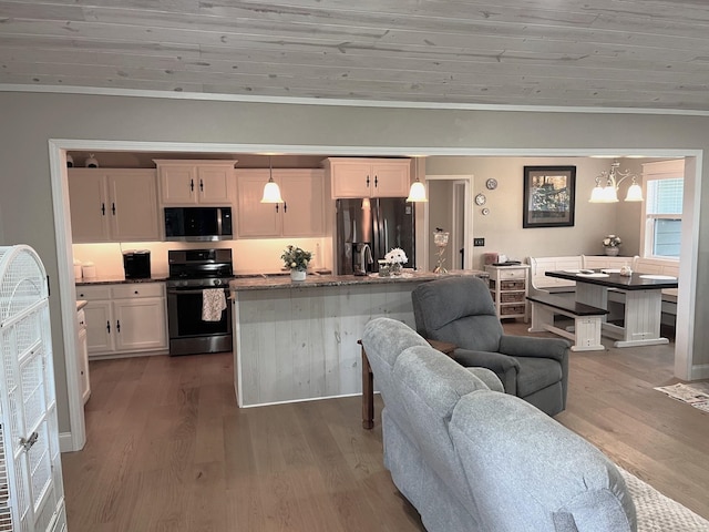 758 Barren Fork Rd, Mount Pleasant, AR 72561 - kitchen featuring appliances with stainless steel finishes, open floor plan, wood finished floors, ornamental molding, and dark stone counters
