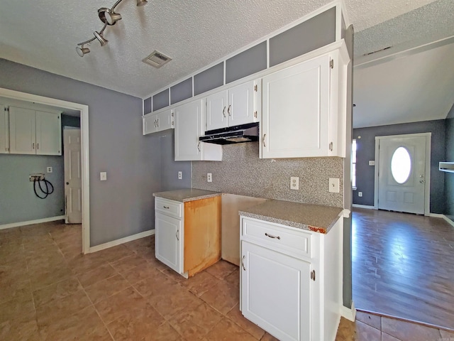 18 Langford St, Ward, AR 72176 - kitchen featuring under cabinet range hood, tasteful backsplash, white cabinets, a textured ceiling, and track lighting